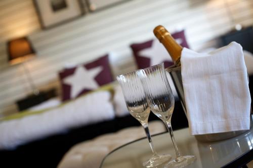 twee wijnglazen op een tafel met een fles champagne bij Hotell Tinget in Sala