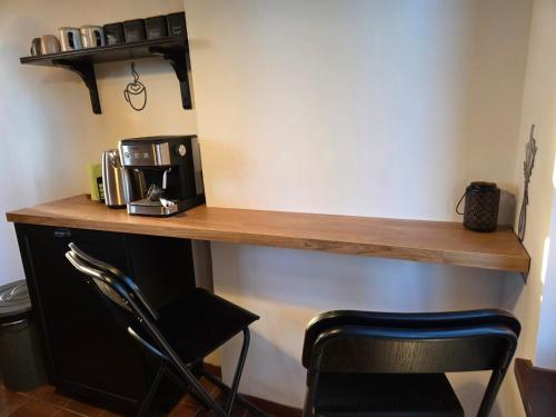 a wooden counter with a coffee maker and a chair at Still Garden House in Bezden