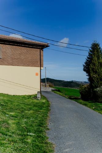 an empty road next to a brick building at Casa Raíces de PO in Lapoblación