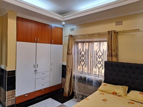 a bedroom with a bed and a large window at Golden View Guest House in Lilongwe