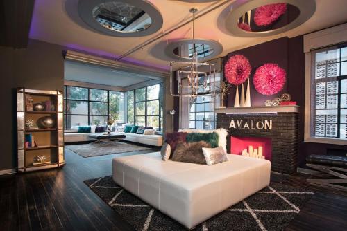 a living room with a white couch and a fireplace at Avalon Hotel Downtown St. Petersburg in St Petersburg