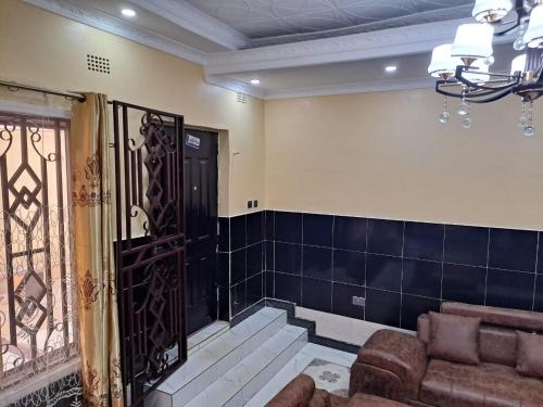 a living room with a couch and a black door at Golden View Guest House in Lilongwe