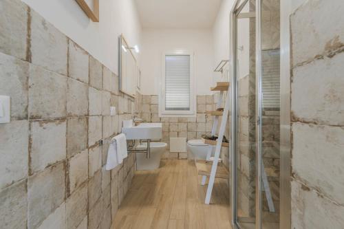a bathroom with a toilet and a sink at Cave Garden rooms in Favignana