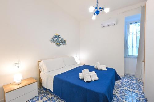 a bedroom with a blue bed with towels on it at La Casa del Mozzo in Ischia