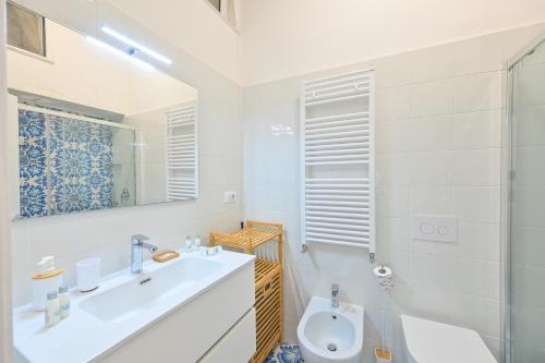 a bathroom with a sink and a toilet and a mirror at La Casa del Mozzo in Ischia