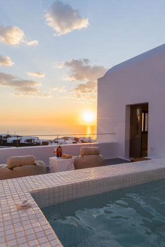 a villa with a swimming pool and a sunset at Niabelon Suites - Private Jacuzzi Sunset View in Oia
