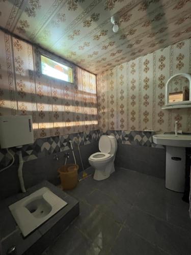 a bathroom with a toilet and a sink at Peak Paradise Resort in Taobat