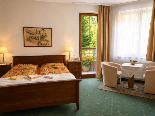 a hotel room with a bed and a table and chairs at Kristoff Plaza Trencianske Teplice in Trenčín