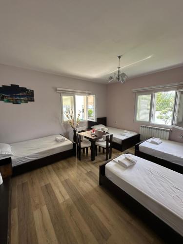 a room with three beds and a table at Bujtina cela in Berat