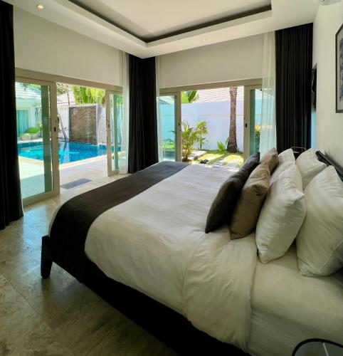 a bedroom with a large bed with a view of the ocean at Baan Tai Tara 4, Private Pool Villa by Ban Tai Beach in Ban Tai