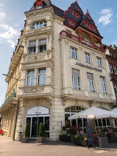 a large building with a sign in front of it at Hotel Porta Nigra VICTUS in Trier