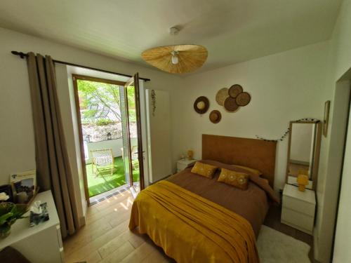 a bedroom with a bed and a sliding glass door at Le refuge des deux âmes in Alby