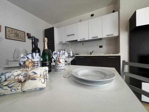 a kitchen with a table with a plate and wine glasses at Residence Mairen a pochi passi dal mare in Rosolina Mare