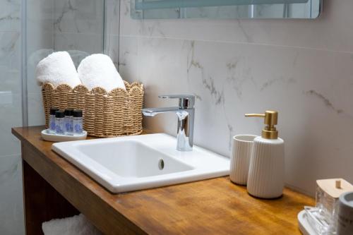 a bathroom sink with towels on a wooden counter at Aura 2 Apartment in Vathý