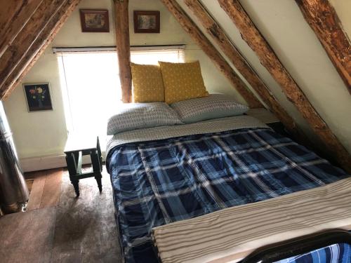 a bedroom with a bed in a attic at East cross forest log cabin in Burketon Station