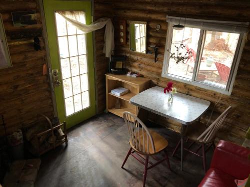 a dining room with a table and chairs in a cabin at East cross forest log cabin in Burketon Station
