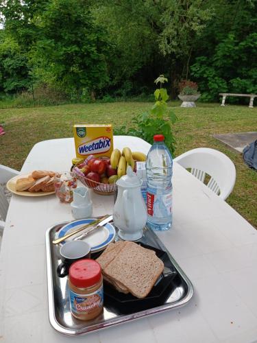 a picnic table with a tray of food and a basket of fruit at Sérénité in Corquilleroy