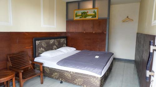 a bedroom with a bed and a chair in it at BROMO B&B in Bromo