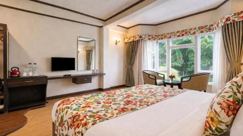 a hotel room with a bed and a television at Lillium Hotel & Spa in Kalimpong