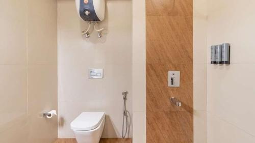 two pictures of a bathroom with a toilet and a shower at Lillium Hotel & Spa in Kalimpong