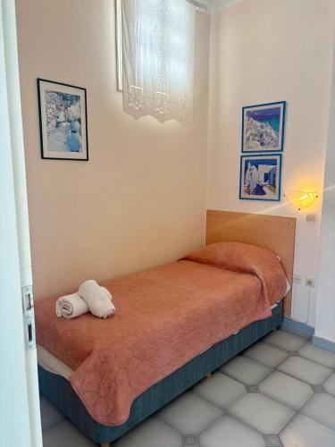 a bedroom with a bed with two towels on it at Sylvia Studios in Agia Marina Aegina