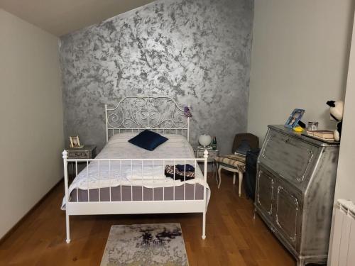 a bedroom with a white bed and a wall at Green Oasis in Danilovgrad