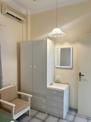 a bathroom with a cabinet and a desk and a chair at Sylvia Studios in Agia Marina Aegina
