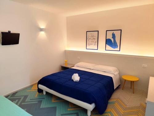 a bedroom with a bed with a blue blanket at Cefalhub in Cefalù
