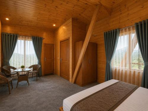 a bedroom with a bed and a table and chairs at APine Cottages - Two Bedroom, One Luxury Getaway in Nārkanda