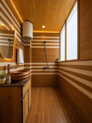 a bathroom with wooden walls and a sink and a window at APine Cottages - Two Bedroom, One Luxury Getaway in Nārkanda