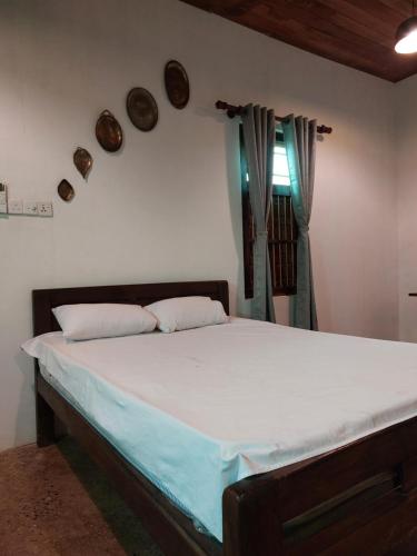 a bedroom with a large bed with white sheets at Karisal Resort & Park in Jaffna