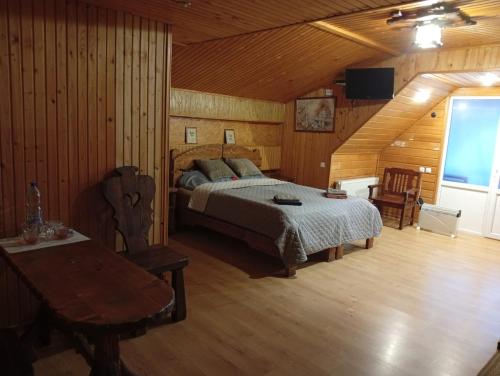 a bedroom with a bed and a table in a room at Motel KOKOS in Kosiv