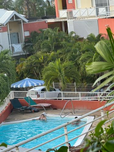a person in the swimming pool at a resort at Studio SUCRIER TARTANE in La Trinité