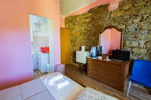 a bedroom with a couch and a stone wall at Casa Vacanza Capozzoli in Albanella