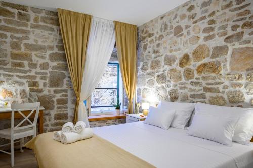 a bedroom with a large bed with a stone wall at Apartments Festum in Šibenik
