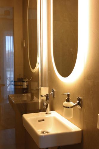 a bathroom with a sink and a large mirror at Jaukus loftas Šventoji in Šventoji