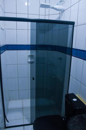 a glass shower in a bathroom with a toilet at Pequena Sereia Guriri in São Mateus