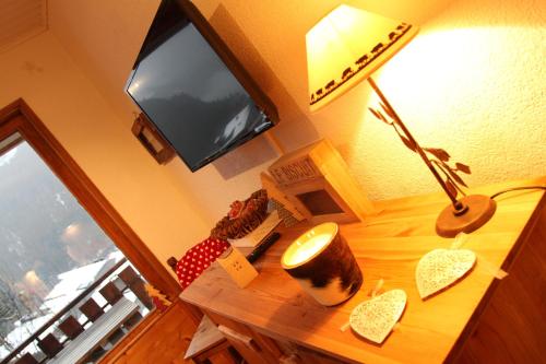 a desk with a lamp and a television on it at Appartement Chatel Centre in Châtel