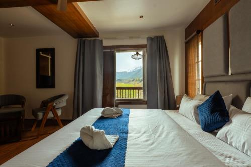a bedroom with a bed with a view of a mountain at Walnut Village Resort in Pahalgām
