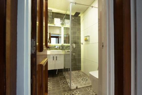 a bathroom with a shower and a sink and a toilet at Walnut Village Resort in Pahalgām