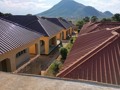 a row of roofs with mountains in the background at Wayekha Hotels in Kasungu