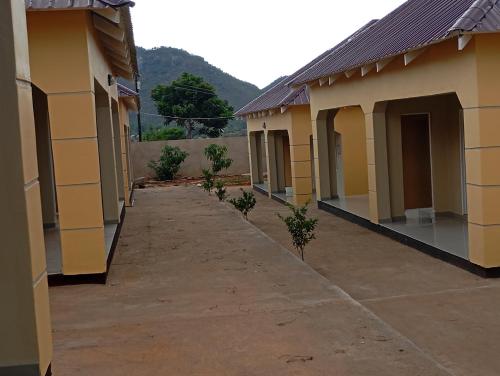 a row of houses with a walkway between them at Wayekha Hotels in Kasungu