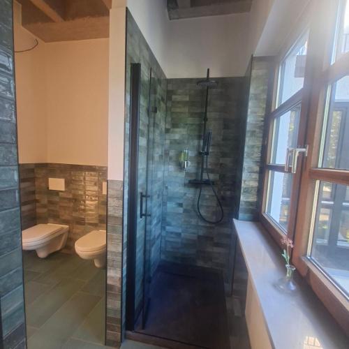 a bathroom with a shower and a toilet at Estelada Studios Unterhaching in Unterhaching