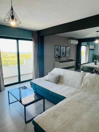 a living room with a white couch and a glass table at Villa Alina with heated pool in Rogoznica