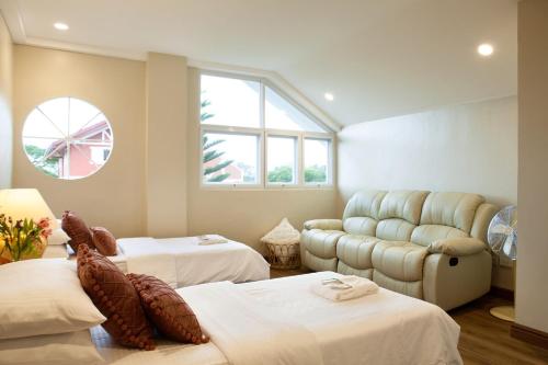 a room with two beds and a couch at Balay Pahuwai Bed & Breakfast in Tagaytay