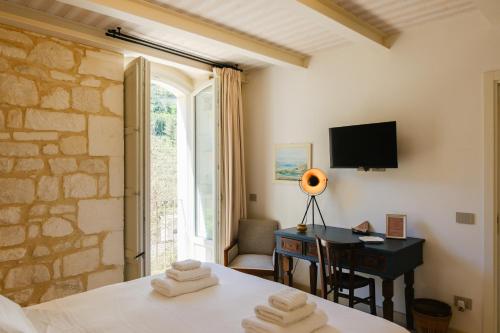 a bedroom with a bed and a desk and a window at Spighe e Fenicotteri in Modica
