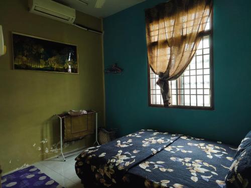 a bedroom with a bed and a window at Irman Homestay Pendang in Pendang