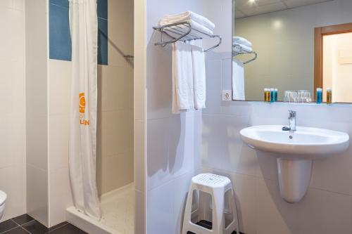 ein weißes Badezimmer mit Waschbecken und Dusche in der Unterkunft Hotel Golden in Benidorm