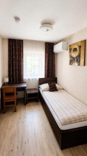 a bedroom with two beds and a desk and a window at Pikolo - izby na prenájom in Nové Mesto nad Váhom