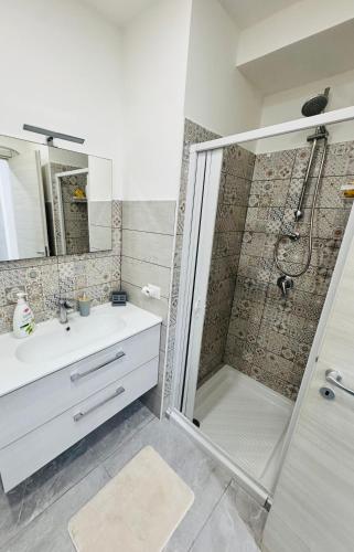 a bathroom with a shower and a sink and a mirror at Ali apartments in Pizzo